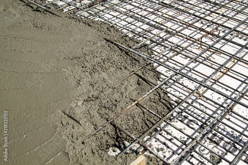 Carta da parati pouring concrete into prepared place with reinforced metal frame