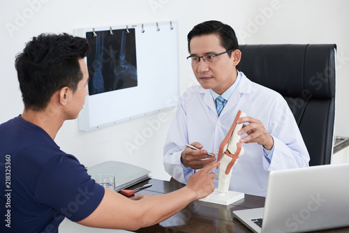 Konstfotografi Doctor explaining structure of joint to patient