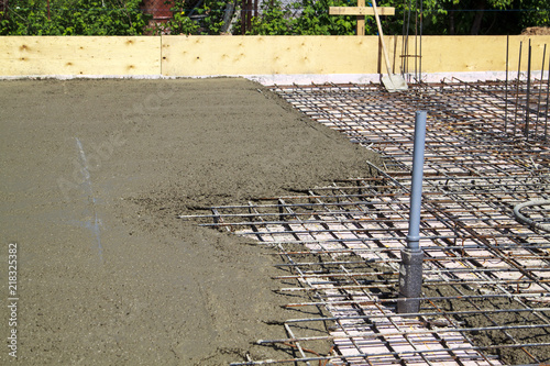 pouring concrete into prepared place with reinforced metal frame
