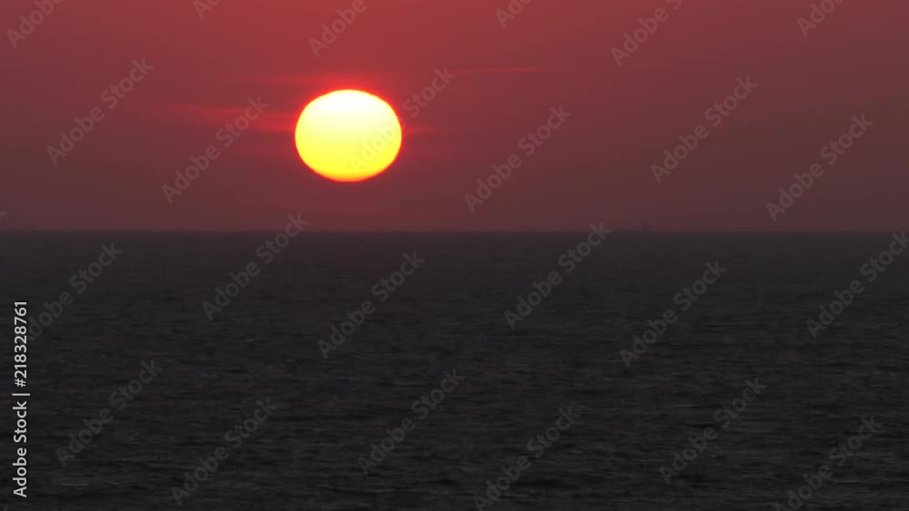 Red sunset. The sun touches the horizon. Calm sea. Small waves. Panning,Closeup, Red sunset. The sun touches the horizon. Calm sea. Small waves. Panning,Closeup,