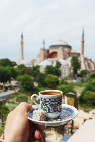 Traditional cup of  turkish coffee in hand with a mosque Ayasofya background.