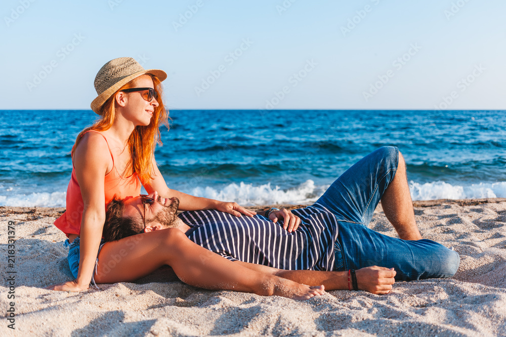 Young couple in love lying on the beach enjoying Young couple in love lying on the beach enjoying