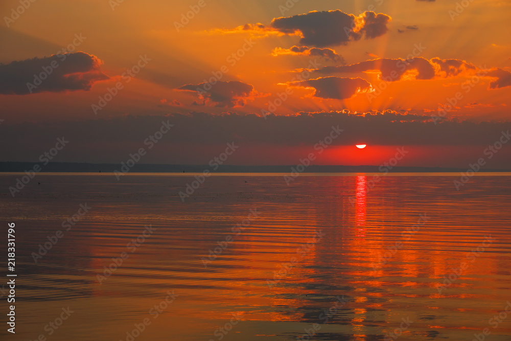 Dramatic sunset sky with clouds over lake. Composition of nature