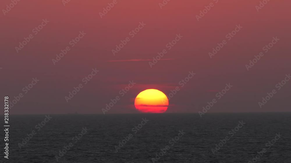 Red sunset. The sun touches the horizon. Calm sea. Small waves. Panning,Closeup, Red sunset. The sun touches the horizon. Calm sea. Small waves. Panning,Closeup,