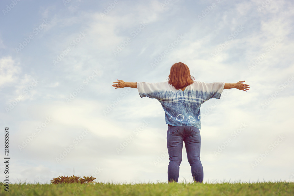 Young happy woman in a nature setting with her arms in the air feeling free, Happy people lifestyle concept. Young happy woman in a nature setting with her arms in the air feeling free, Happy people lifestyle concept.