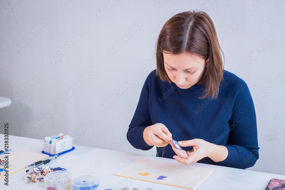 Professional jewelry designer making handmade brooch with beads in studio, workshop. Fashion, creativity and handmade concept Professional jewelry designer making handmade brooch with beads in studio, workshop. Fashion, creativity and handmade concept