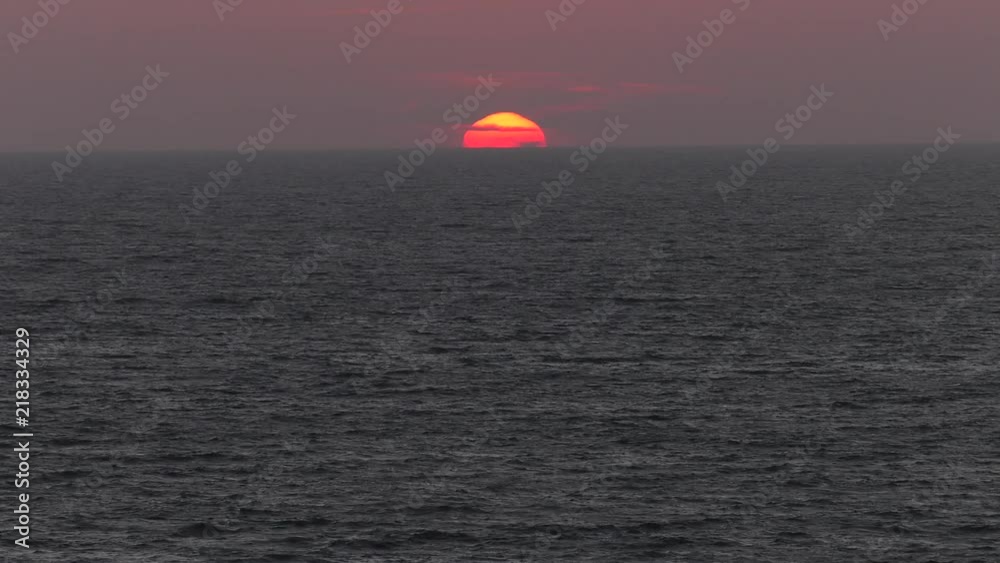 Red sunset. The sun touches the horizon. Calm sea. Small waves. Panning,Closeup, Red sunset. The sun touches the horizon. Calm sea. Small waves. Panning,Closeup,