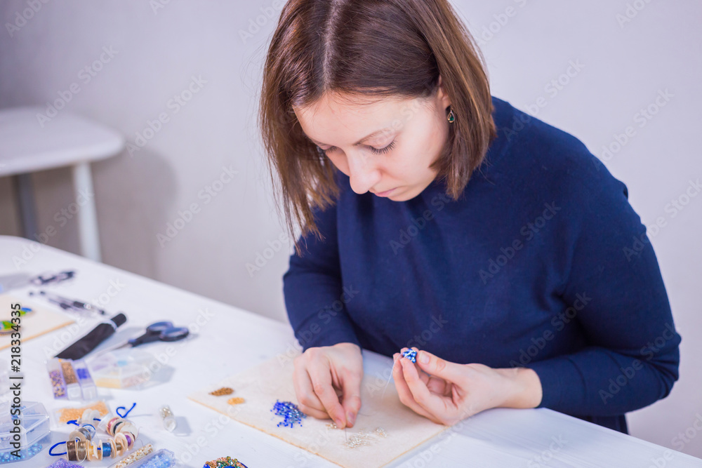 Professional jewelry designer making handmade eardrop with beads in studio, workshop. Fashion, creativity and handmade concept Professional jewelry designer making handmade eardrop with beads in studio, workshop. Fashion, creativity and handmade concept