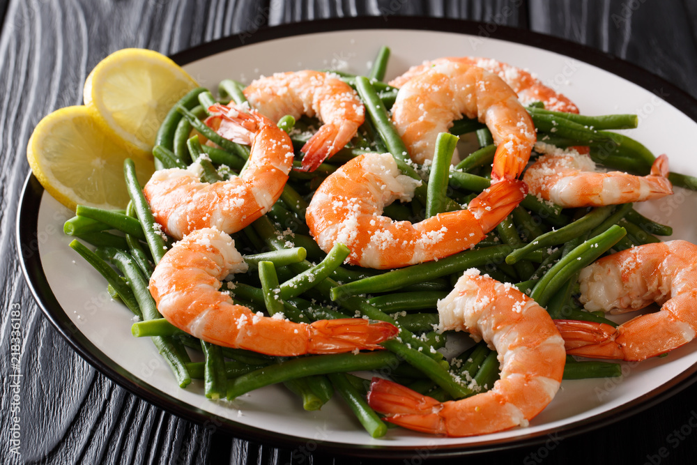 King prawns with green beans, cheese and lemon close-up on a plate. horizontal King prawns with green beans, cheese and lemon close-up on a plate. horizontal