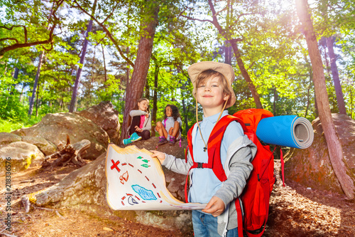 Little boy with treasure map in the forest game photo