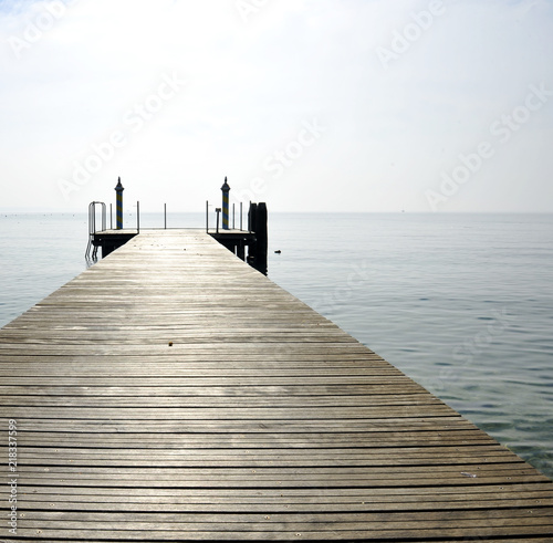 Wooden pier over lake against sky. Bardolino, Italy