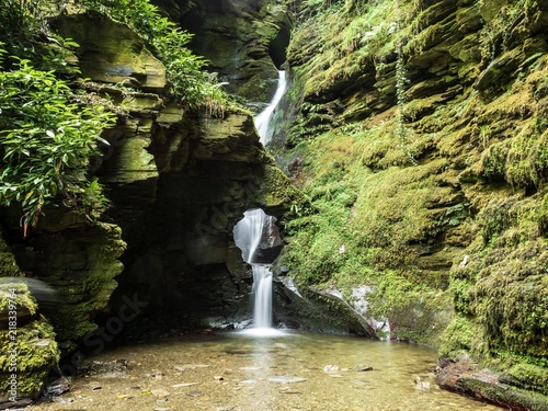 A waterfall through a hole in the rock at St Nectan's Glen in Cornwall photo