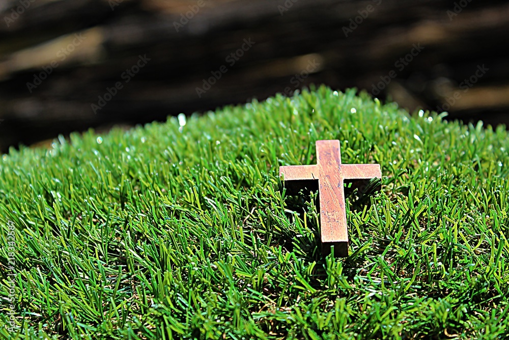 Blurred image. Christian crosses made of wood on a green background. Blurred image. Christian crosses made of wood on a green background.