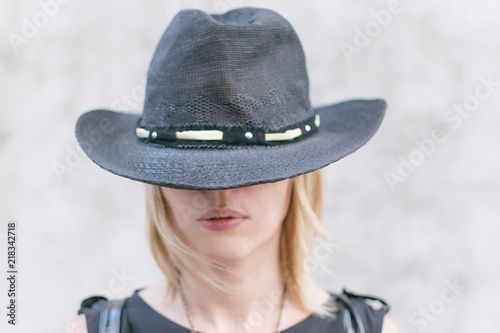 A woman incognito in a black hat covering her face.