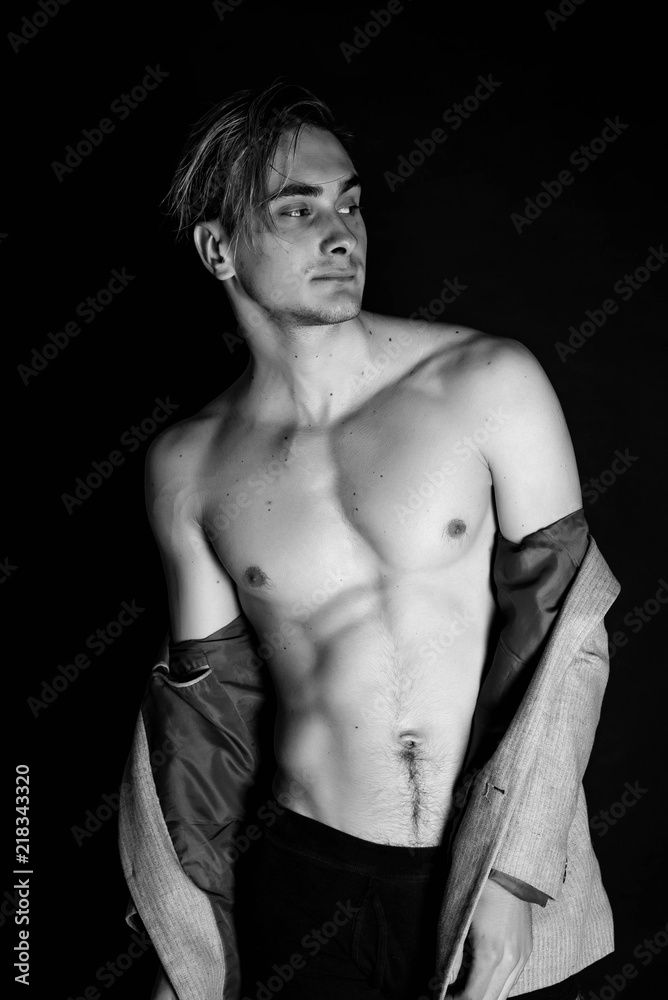 Portrait of fashion young caucasian sexy muscled attractive handsome athletic man boy model isolated on black background