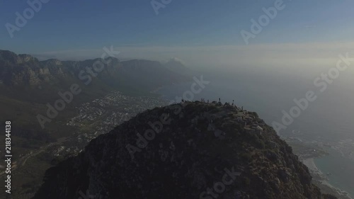 Spectacular Panoramic Aerial shot of Lions Head Peak during Sunset in Cape Town, showing the ocean and Table Mountain