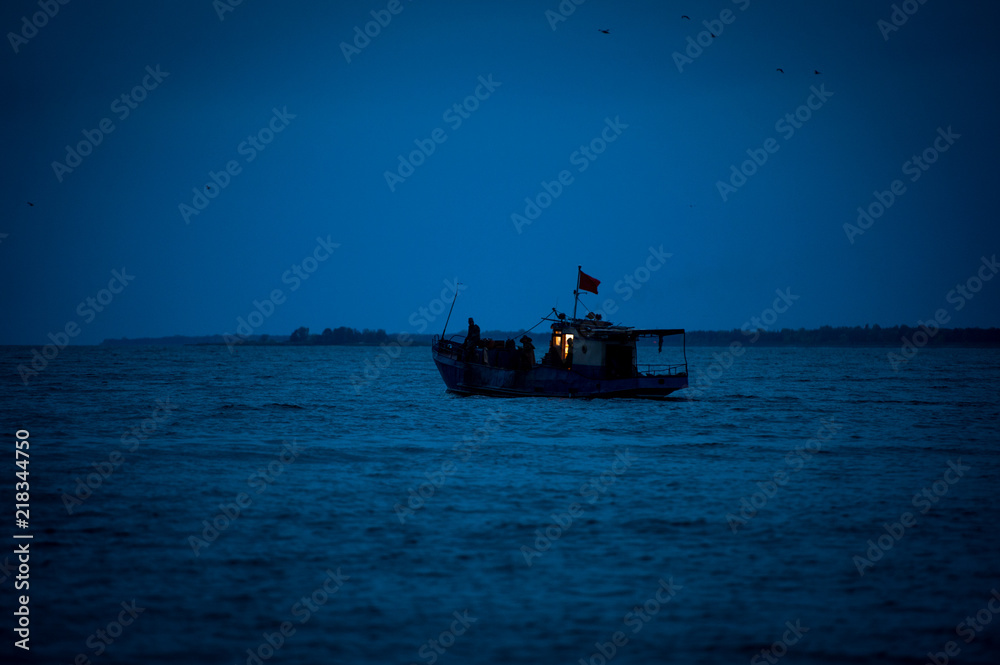 Fishing boat goes to sea. Ship at sea. Seiner goes to sea. 
A ship at dawn in the sea. Fishing boat at night at sea.