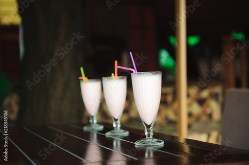 Three milkshakes and smoothies on wooden table