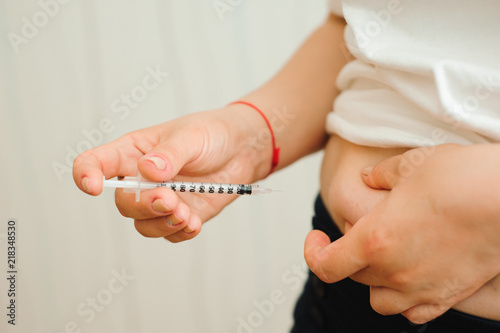 medicine  diabetes  glycemia  health care and people concept - close up of woman hands making injection with insulin pen or syringe