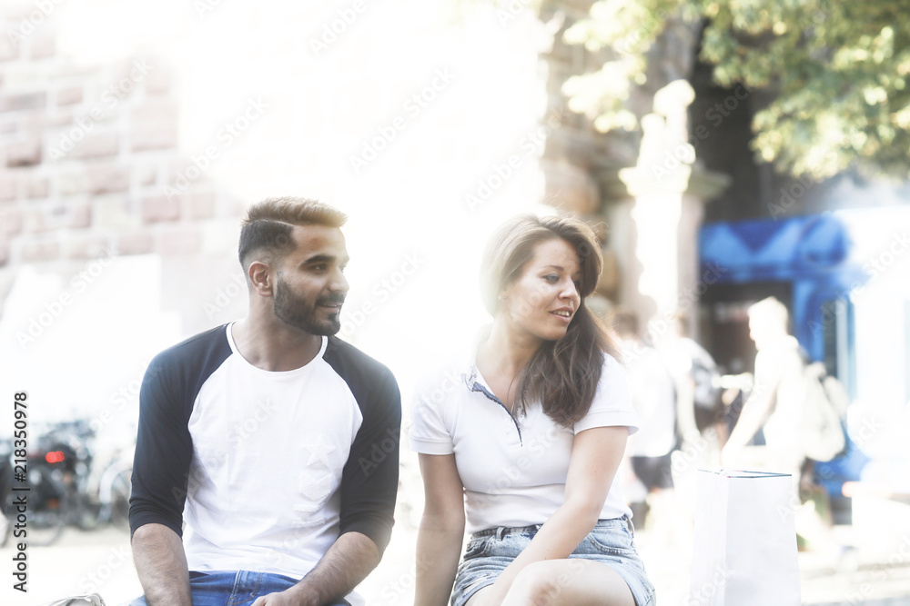 Fototapeta premium Junges Paar auf einer Mauer in der Altstadt sitzend