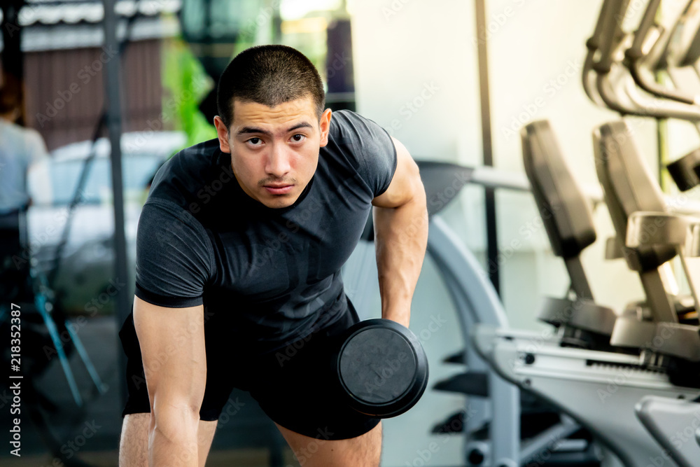 Young sport man exercising in fitness gym Young sport man exercising in fitness gym