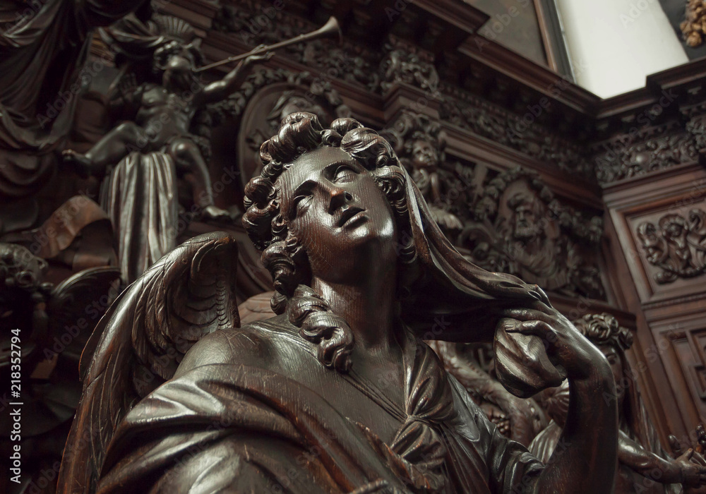 Angel with emotional expression or reflections, wooden statue in 12th century Saint Michael's church