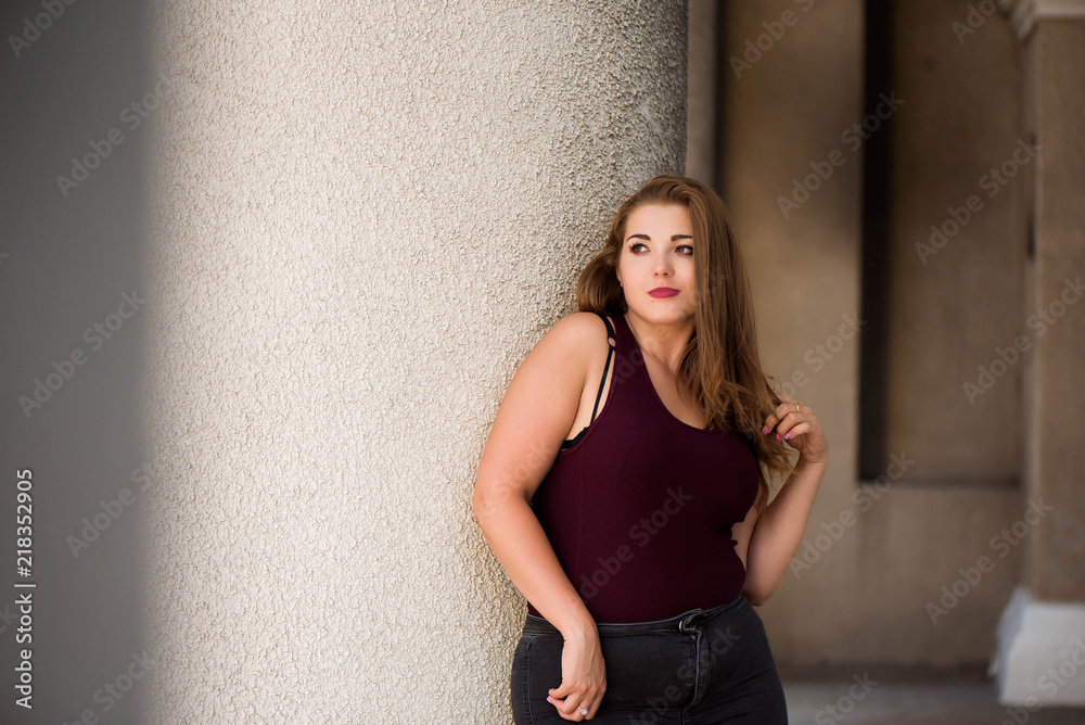 Young stylish woman walking on the city street in summer. Plus size model. Young stylish woman walking on the city street in summer. Plus size model.