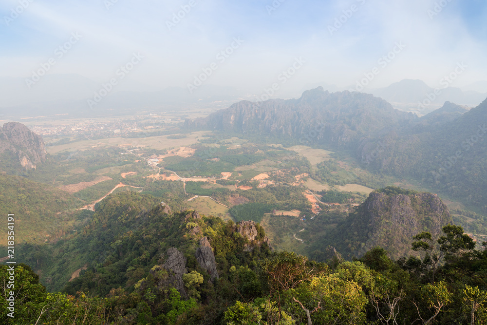 Fototapeta premium Scenic view of Vang Vieng and the surrounding area from above from the Phangern (Pha Ngern, Pha ngeun) mountain in Laos on a sunny day.