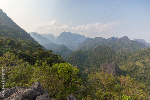 Scenic view of lush mountains and hills near Vang Vieng in Laos on a sunny day.