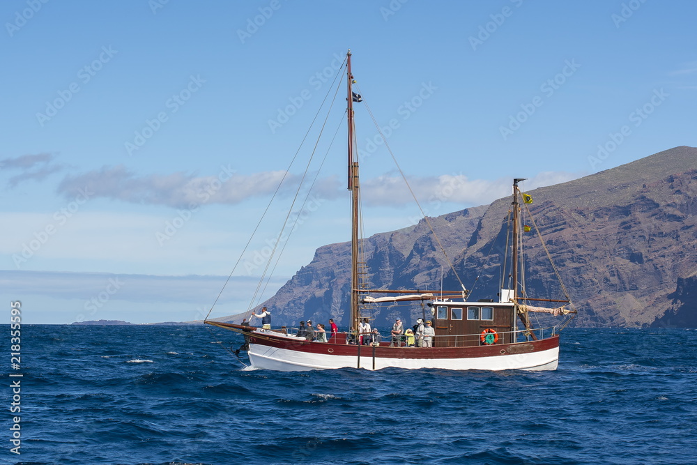 Yacht with tourists near Los Gigantes looking for whales and dolphins, Tenerife, Canary islands, Spain Yacht with tourists near Los Gigantes looking for whales and dolphins, Tenerife, Canary islands, Spain
