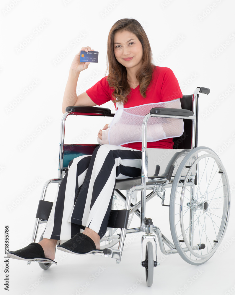 Broken Asian woman with arm sling sponsored in her hands sitting on a wheelchair Ideas for accident Injuries and health care Studio shot on white background. Broken Asian woman with arm sling sponsored in her hands sitting on a wheelchair Ideas for accident Injuries and health care Studio shot on white background.
