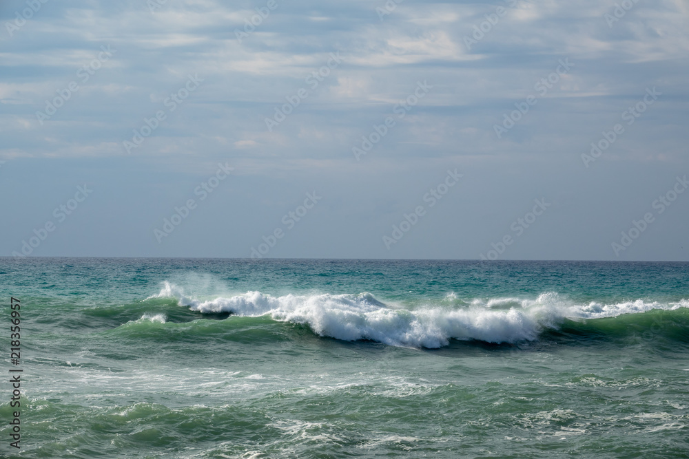 Fototapeta premium White ocean waves crashing to rocks