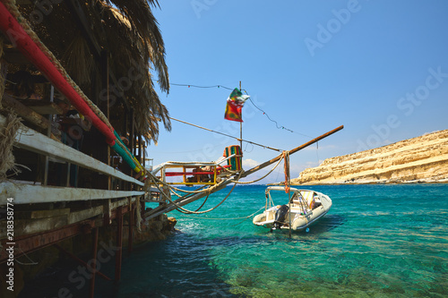Matala beach with boat on clear sea photo