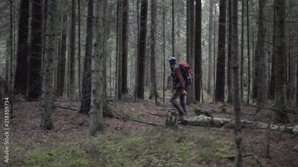 Outdoorsy photographer with a backpack and head lamp walking in forest, gimbal tracking shot Outdoorsy photographer with a backpack and head lamp walking in forest, gimbal tracking shot