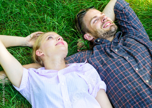Nature fills them with freshness and peace. Man unshaven and girl lay on grass meadow. Guy and girl happy carefree enjoy freshness of grass. Closer to nature. Couple in love relaxing lay at meadow