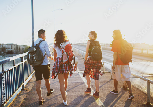 Four young student tourists walking over the bridge on a hot summer day. © dusanpetkovic1