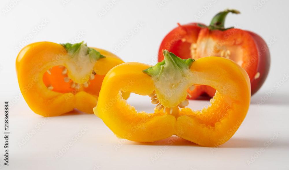 three cut peppers. two yellow and one red. presented on a light background three cut peppers. two yellow and one red. presented on a light background