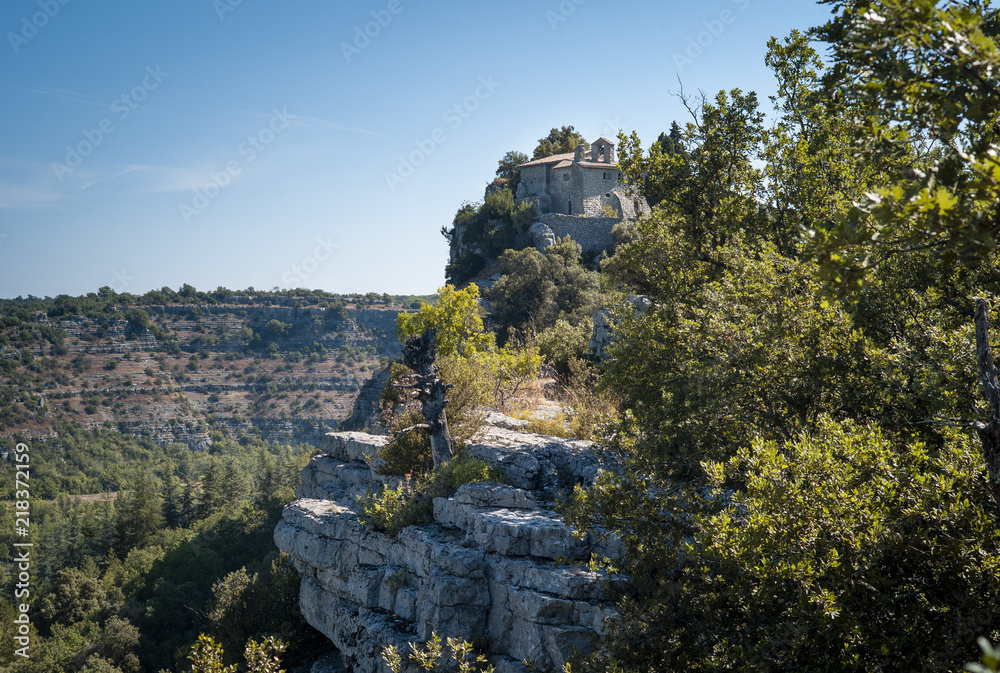 Naklejka premium L'ermitage Saint-Eugène est niché au bord d'une falaise dans le Bois de Païolive, près des Vans, Ardèche, FRANCE, 10 juillet 2018