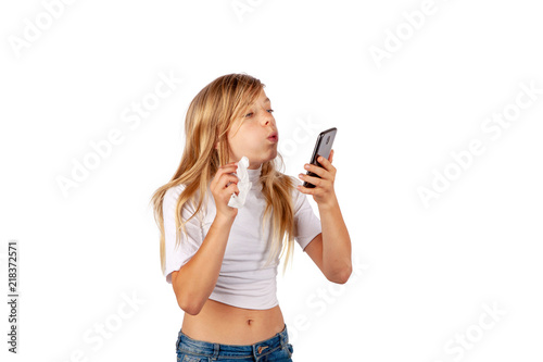 Young girl cleaning her smartphone. Isolated on white background.