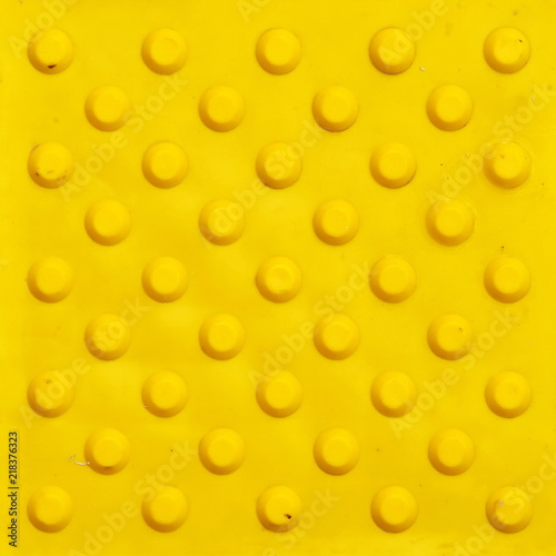 Obraz na płótnie Top view of footpath tiles. Yellow circle buttons pattern. A stop signal for blind person. Solid square background w salonie
