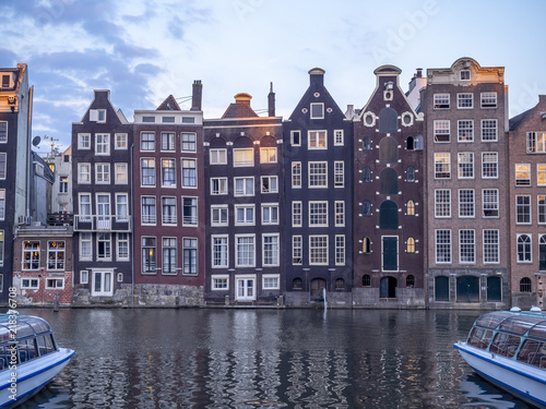 Historic buildings on the Damrak canal in the centre of beautiful Amsterdam at night.