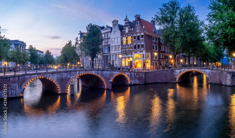 Naklejka premium Bridge over Keizersgracht - Emperor's canal in Amsterdam, The Netherlands at twilight.