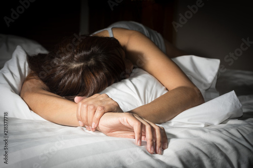 Sad female crying on bed.
