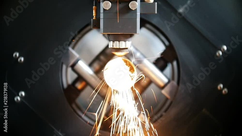 Cutting of metal, sparks fly from laser, modern tool in heavy industry. photo