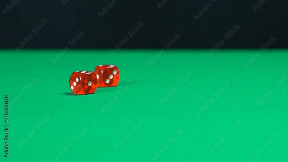 Red dice roll over casino table in slow motion, gambling background, games. Fortune, gambling, money