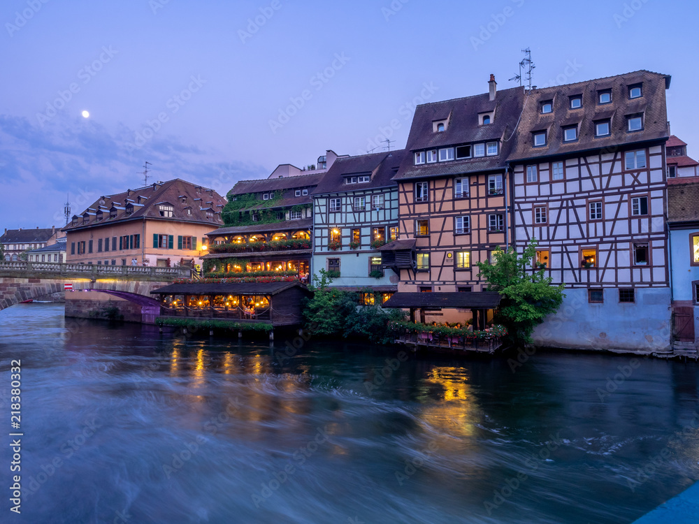 Sunset along the Ill River in Petite France areas of Strasbourg in the Alsace region of France. The homes are the traditional half timbered houses visible all over this area of France.