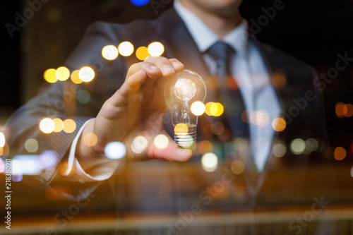 Businessman showing a burning light bulb.