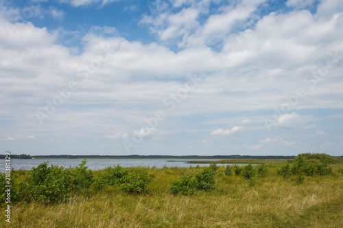 Lake on a sunny day with blue sky and white clouds.