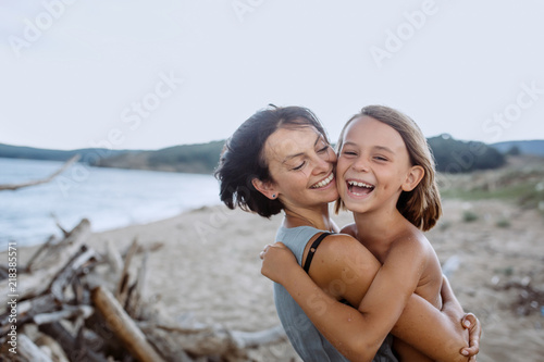 Mother holding her son and laughing at the beach