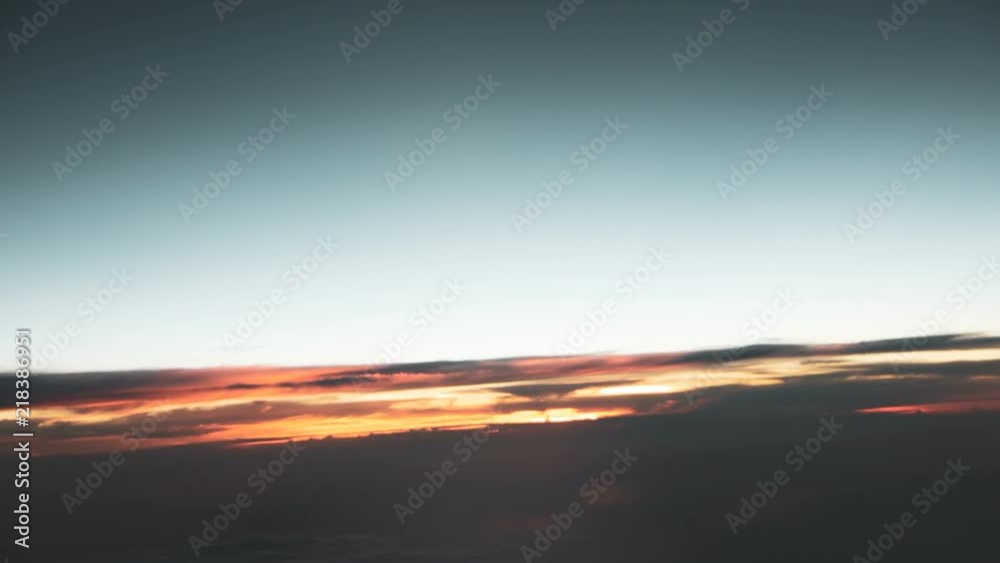 View through airplane window, flying over the clouds in the dark with small turbulence. View through airplane window, flying over the clouds in the dark with small turbulence.